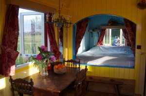 Slaapgedeelte van de pipowagen waar je in Poppel kunt logeren met uitzicht op de velden.